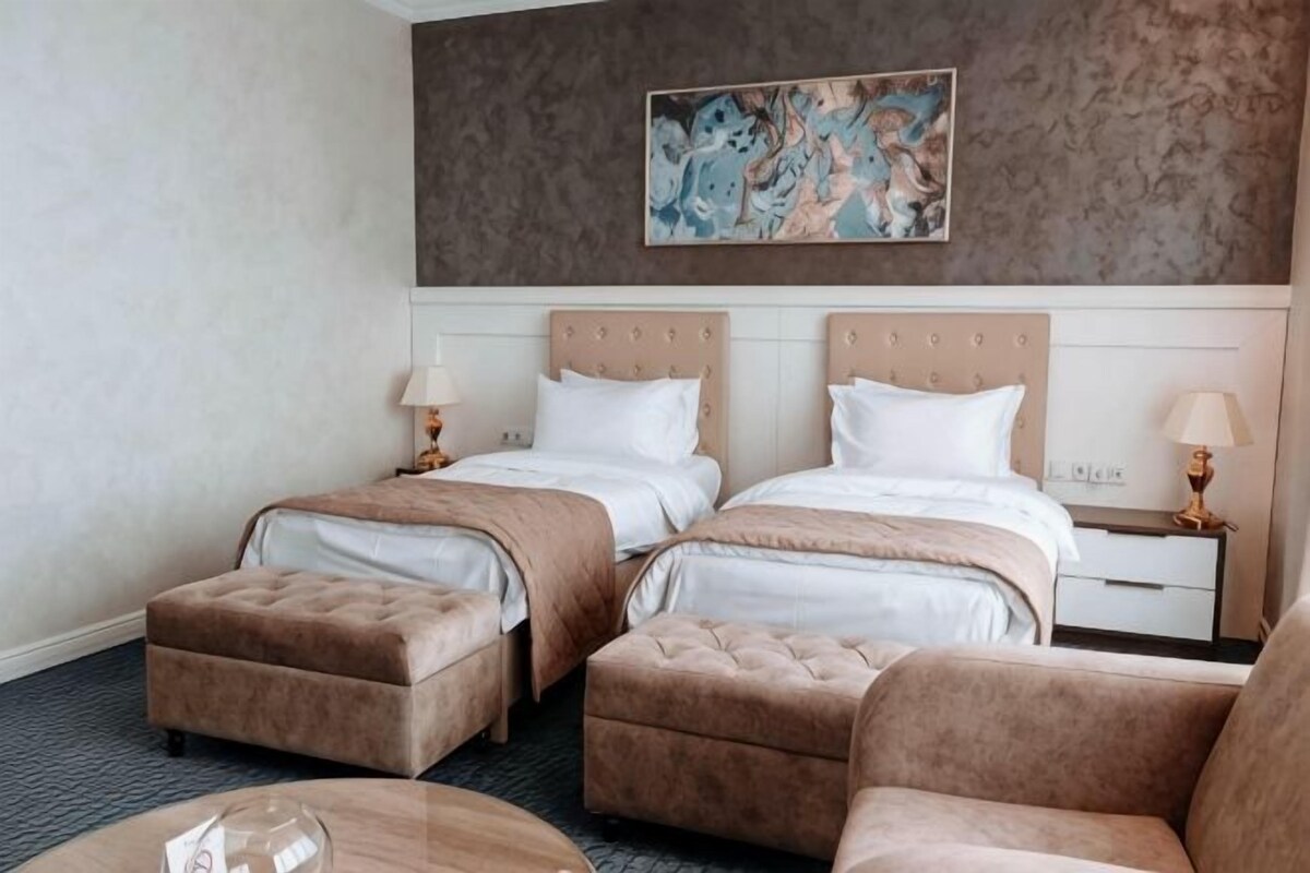 Una habitación de hotel con dos camas, un sofá y una mesa de centro.