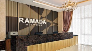 A reception desk with a modern design, featuring a marble top and a geometric patterned backdrop. - Ramada by Wyndham Shymkent (Shymkent)