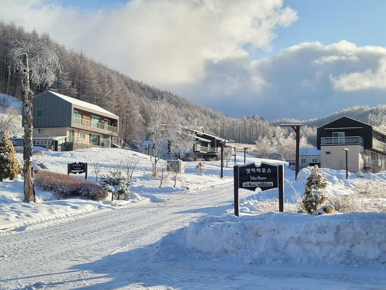 Paisaje nevado con edificios y un cartel que indica un hotel llamado 'Edge House'.