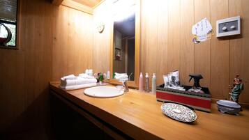 Un baño de madera con un lavabo, espejo y varios artículos de tocador.