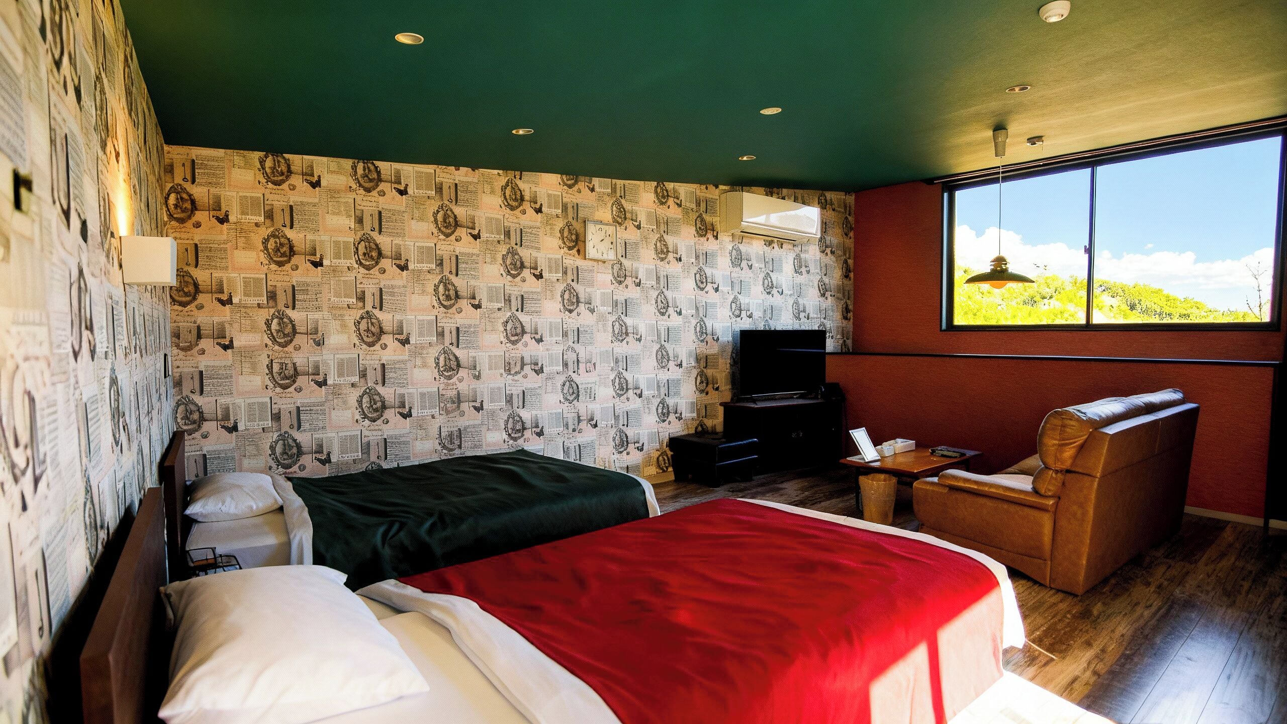 Quarto com duas camas, televisão, uma cadeira e uma janela grande com vista.