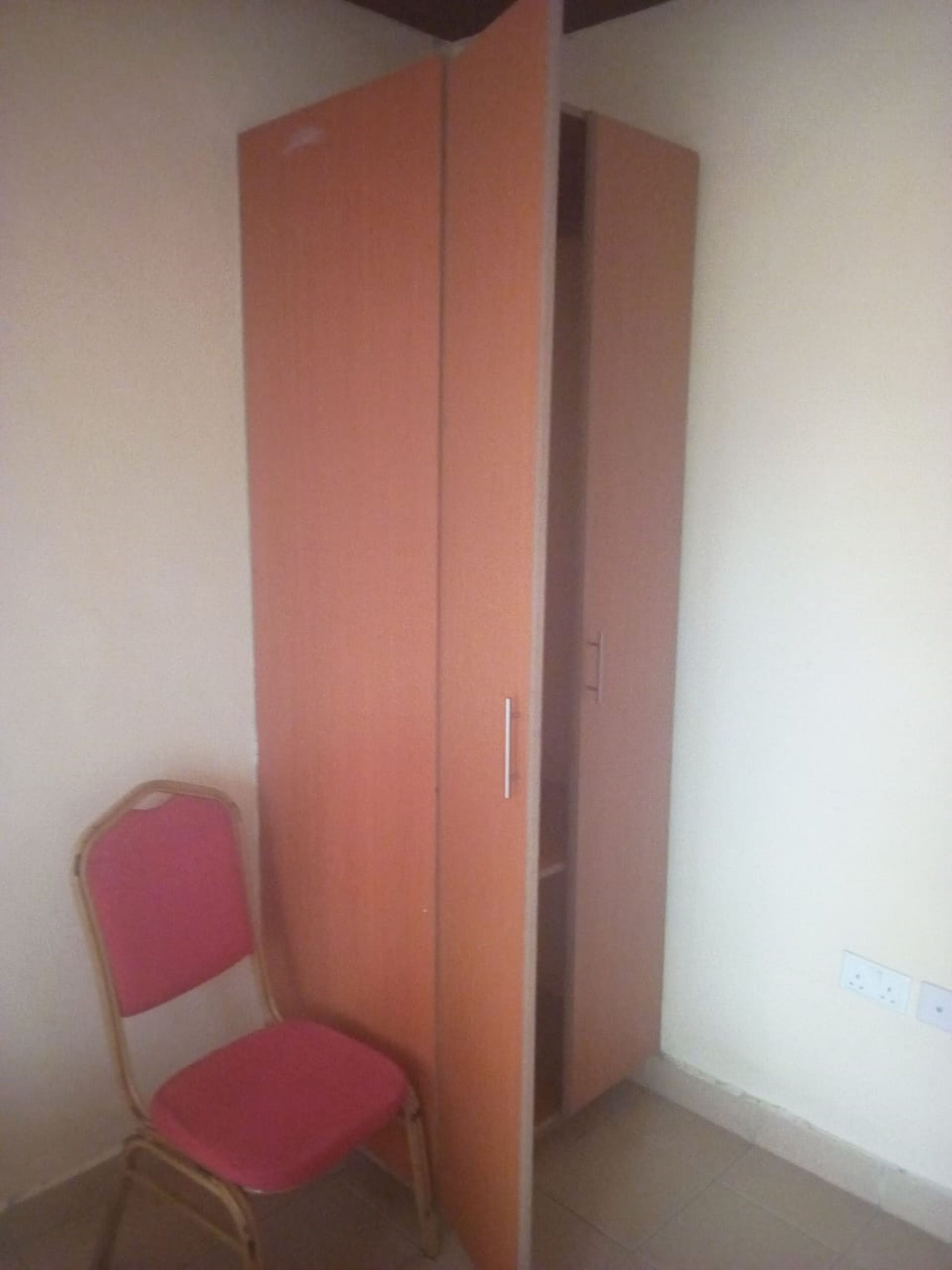 Ein Zimmer mit einem Sessel und einem Kleiderschrank.