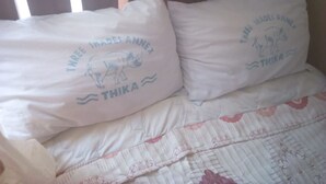 A bed with two pillows featuring a rhino and text. - 3 Shades Annex - Adults Only (Thika)