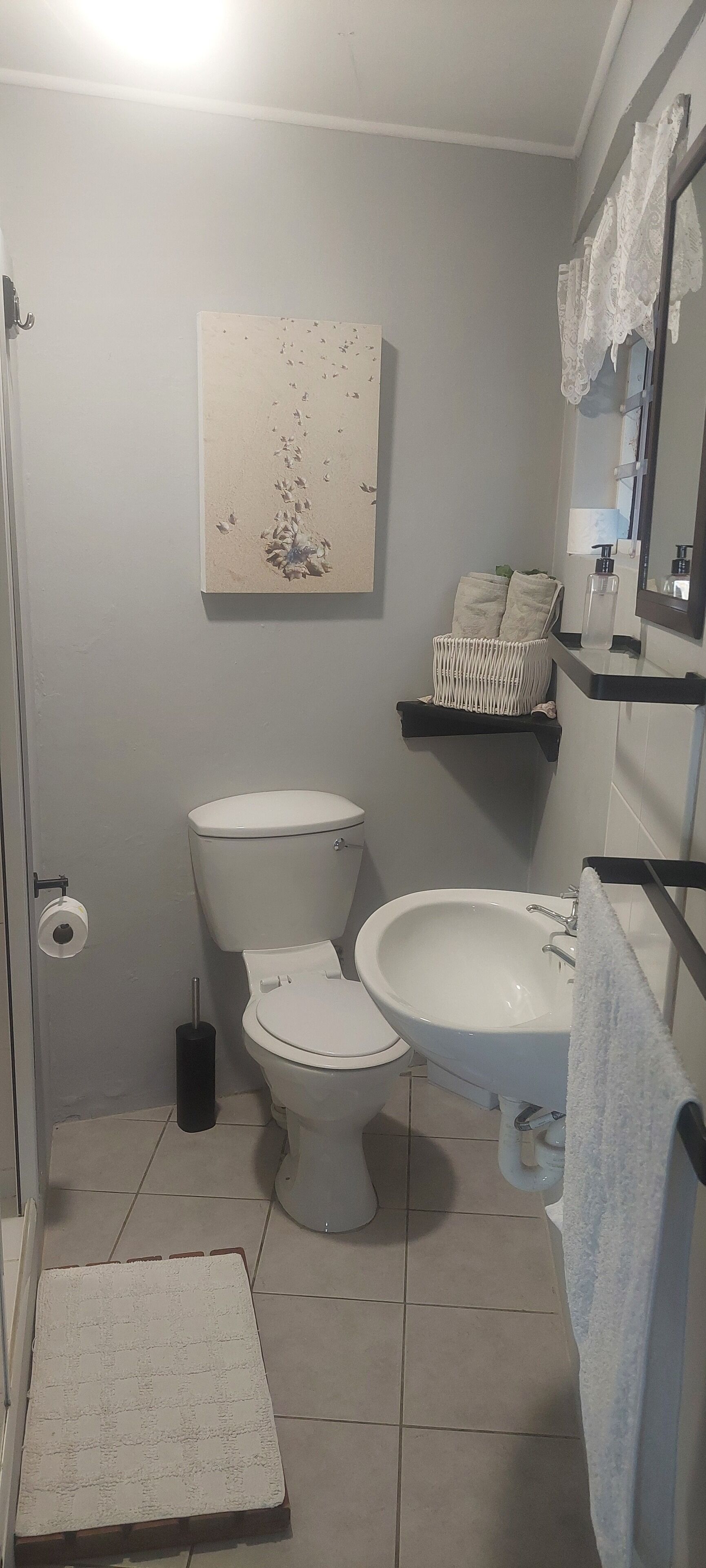 A bathroom with a toilet, bidet, sink, and a towel rack.