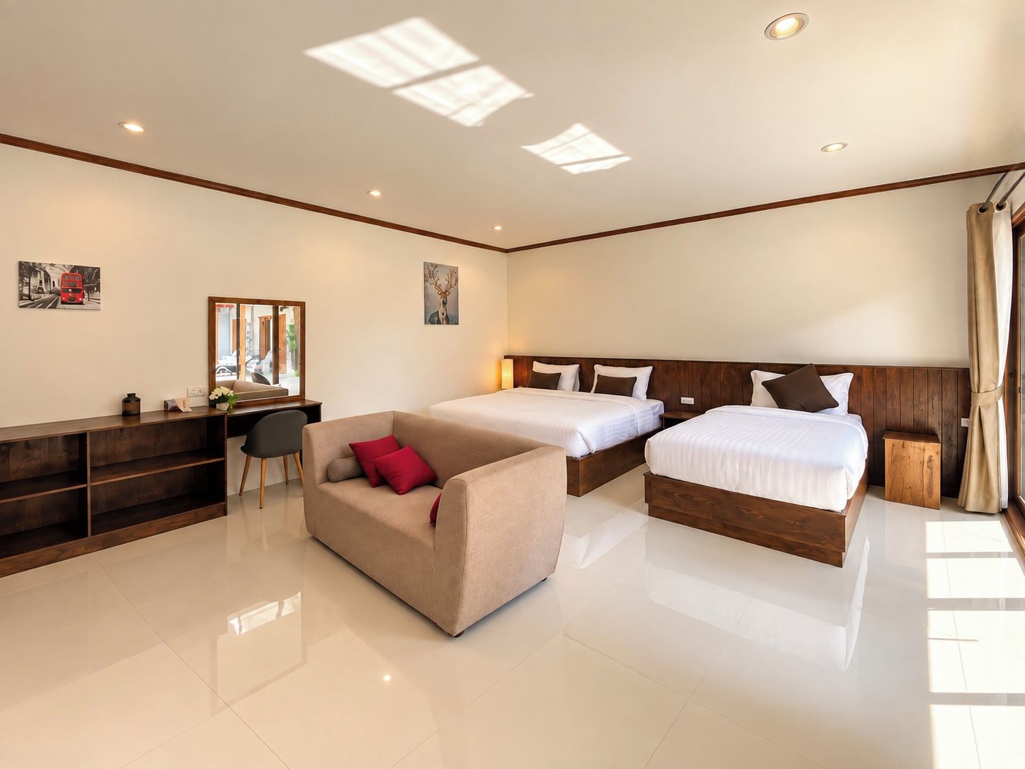 A hotel room with a bed, a sofa, a desk, and a mirror.