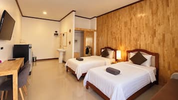 Habitación de hotel con dos camas, un escritorio, un televisor y un baño.