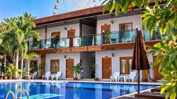 Ein Hotel mit Swimmingpool, mehreren Balkonen und Außenbereich zum Sitzen.