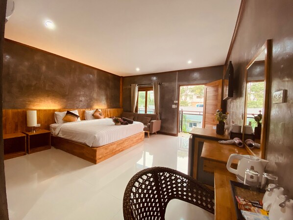 A modern bedroom with a large bed, bedside tables, a desk, and a chair. - Paradise Land Resort (Pattaya)