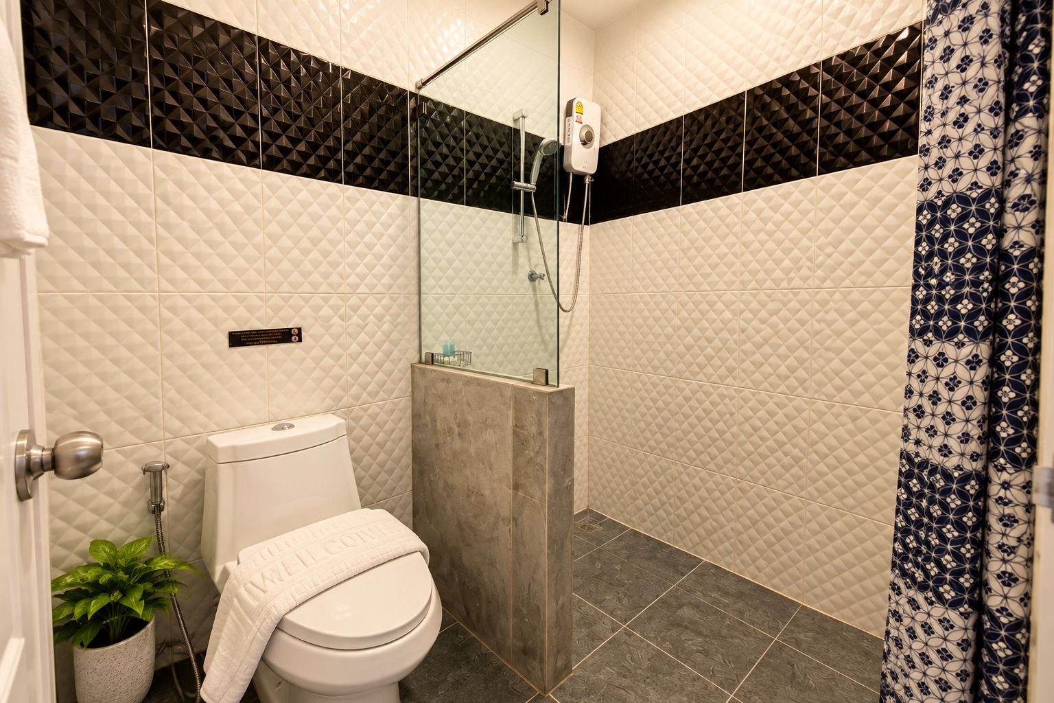 A bathroom with a toilet, a shower, and a sink.