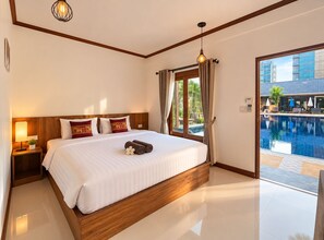 A hotel room with a large bed, a nightstand with a lamp, a window with curtains, and a view of an outdoor swimming pool. - Paradise Land Resort (Pattaya)