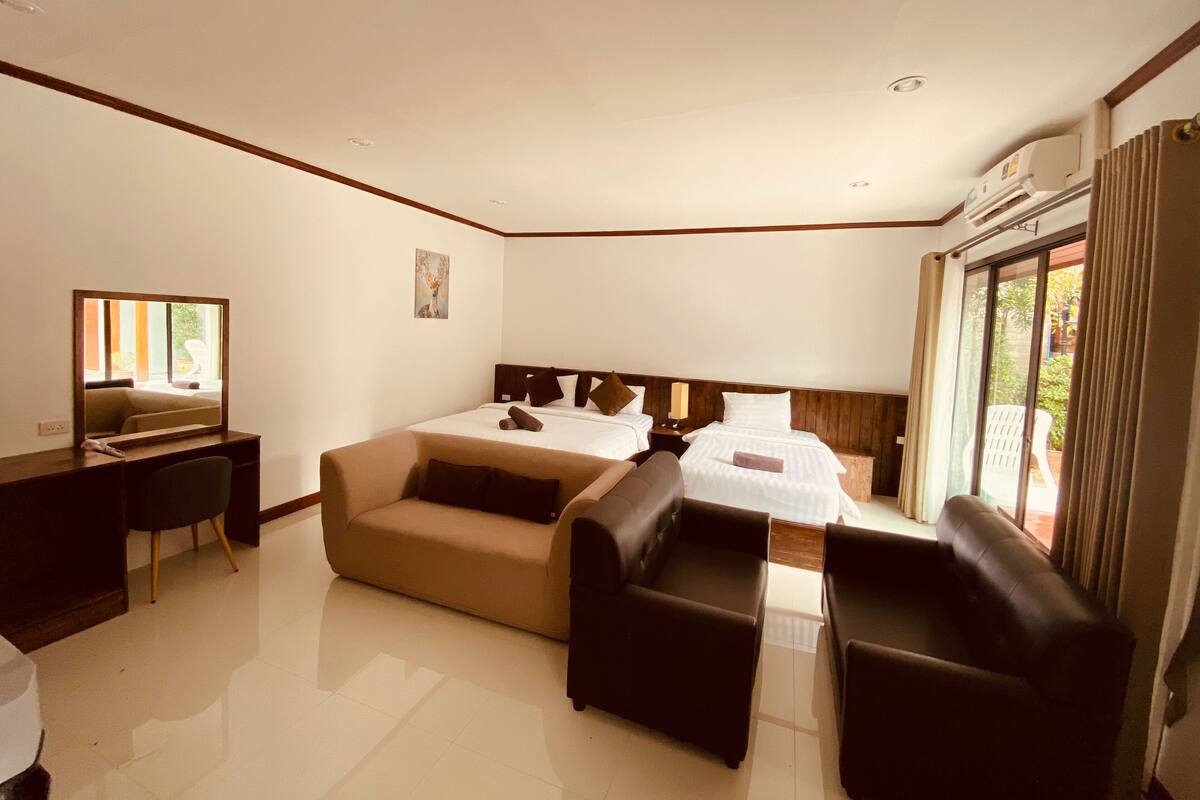 A hotel room with a bed, a desk, a sofa, and a chair.