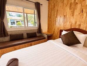 A room with a bed, a bench, a small table, and a window with curtains. - Paradise Land Resort (Pattaya)