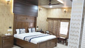 Un dormitorio con una cama de madera, mesitas de noche, un escritorio y una silla.