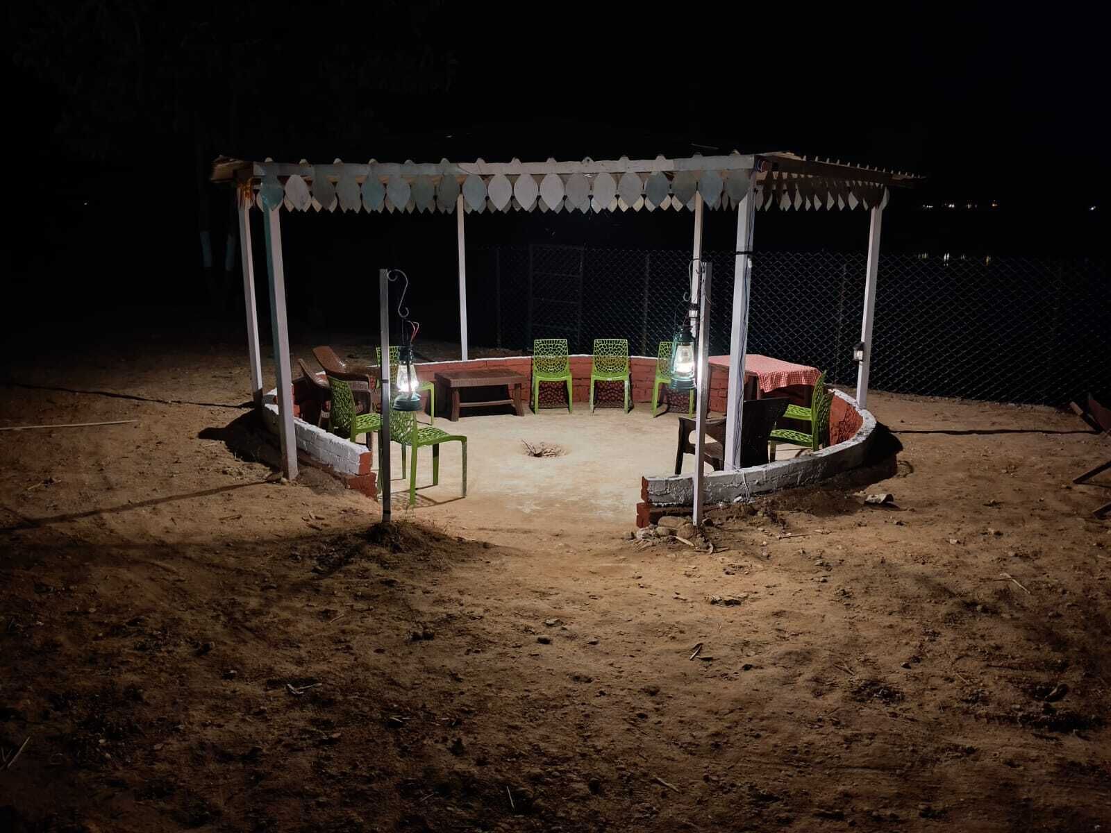Un espacio al aire libre cubierto con mesas y sillas, rodeado por una valla.