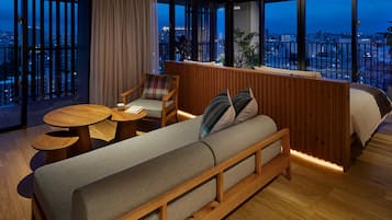 Enjoy a panoramic city view from the comfort of this stylish room, featuring a sofa, coffee table, and armchair.