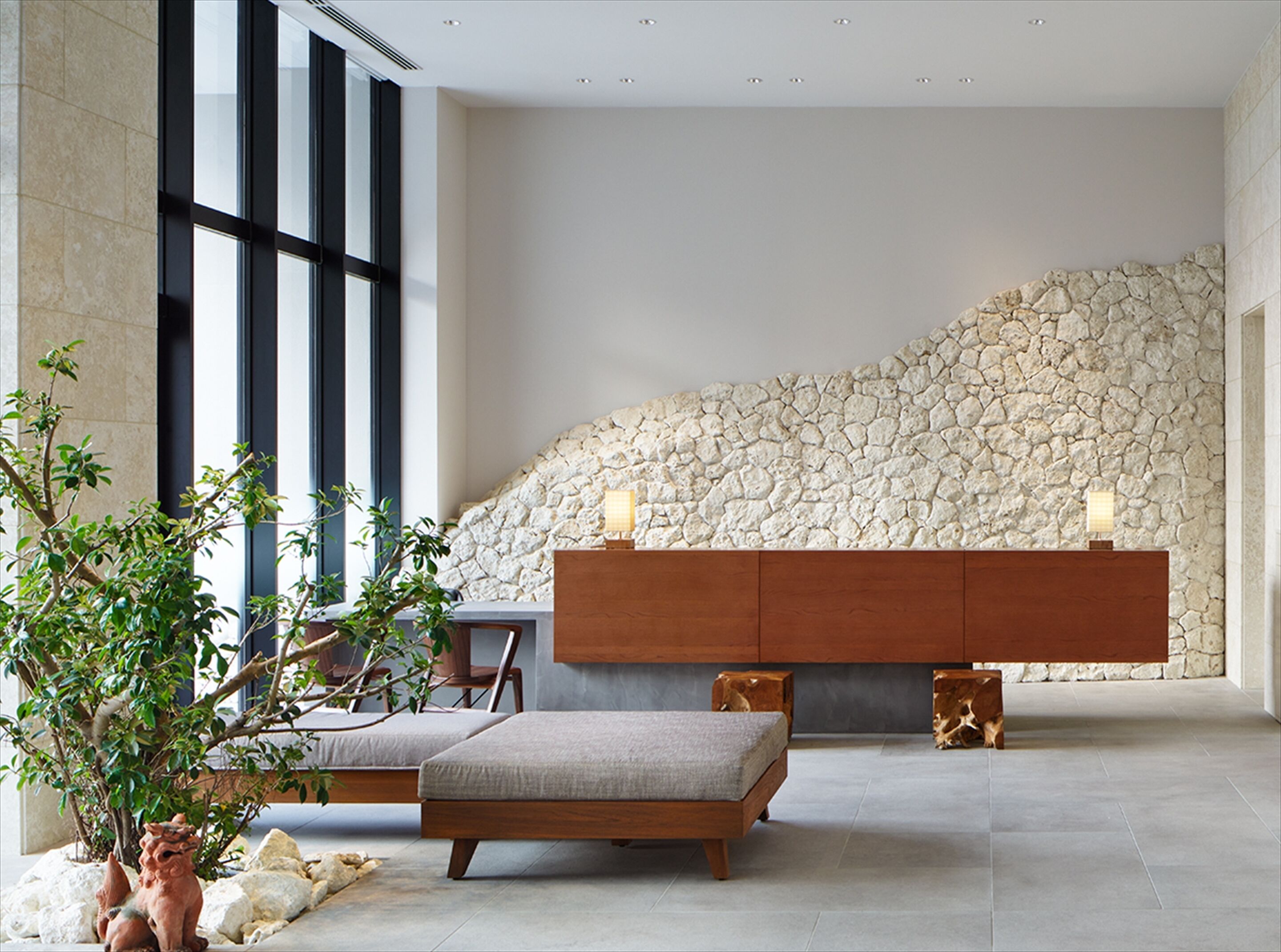 A modern room with a stone wall, a wooden bench, and a small table.