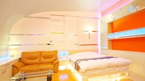 Une chambre moderne avec un lit, un canapé et une table de chevet.