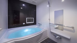 A modern bathroom with a large bathtub, a handheld showerhead, and a wall-mounted TV. - Hotel Baron -the Sweet Modern - Adults Only (Togo)