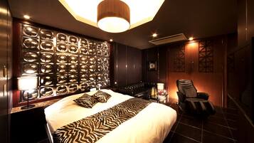 Ein modernes Hotelzimmer mit einem großen Bett, einem Massagesessel und einer Wand aus runden Spiegeln.