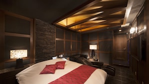 A modern hotel room with a large bed, a stone accent wall, and a wooden ceiling design. - Hotel Baron -the Sweet Modern - Adults Only (Togo)