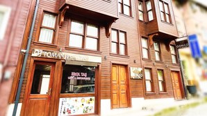A multi-story building with a restaurant named "Toman Restaurant" on the ground floor. - Qonaq Hotel (Istanbul)