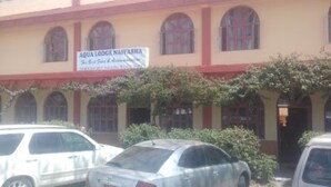 A building with a sign reading "AQUA LODGE NAIVASHA."