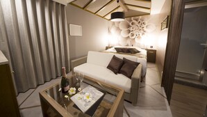 A modern living room with a glass coffee table, a white sofa, and a decorative wall with a unique pattern. - Hotel Dion -dreams IN Resort - Adults Only (Miyoshi)