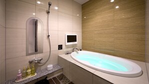 Une salle de bain moderne avec une baignoire sur pieds, une douchette et des toilettes intégrées.