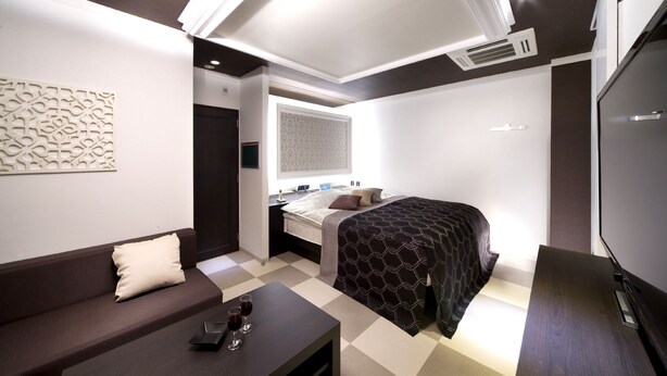 Une chambre d’hôtel moderne équipée d’un lit, d’un canapé, d’un bureau et d’une télévision.