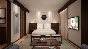 A modern hotel room with a large bed, a TV, a coffee table with a vase and teapot, and a sofa. - Qianna Jiuhe Boutique Hotel Zhoukou Shop (Zhoukou)