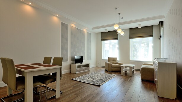 Una sala de estar moderna con una mesa de comedor, sillas, un televisor y un sofá.