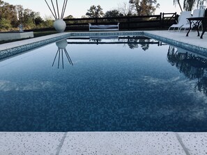 A rectangular swimming pool with a tiled edge and a clear blue water surface.