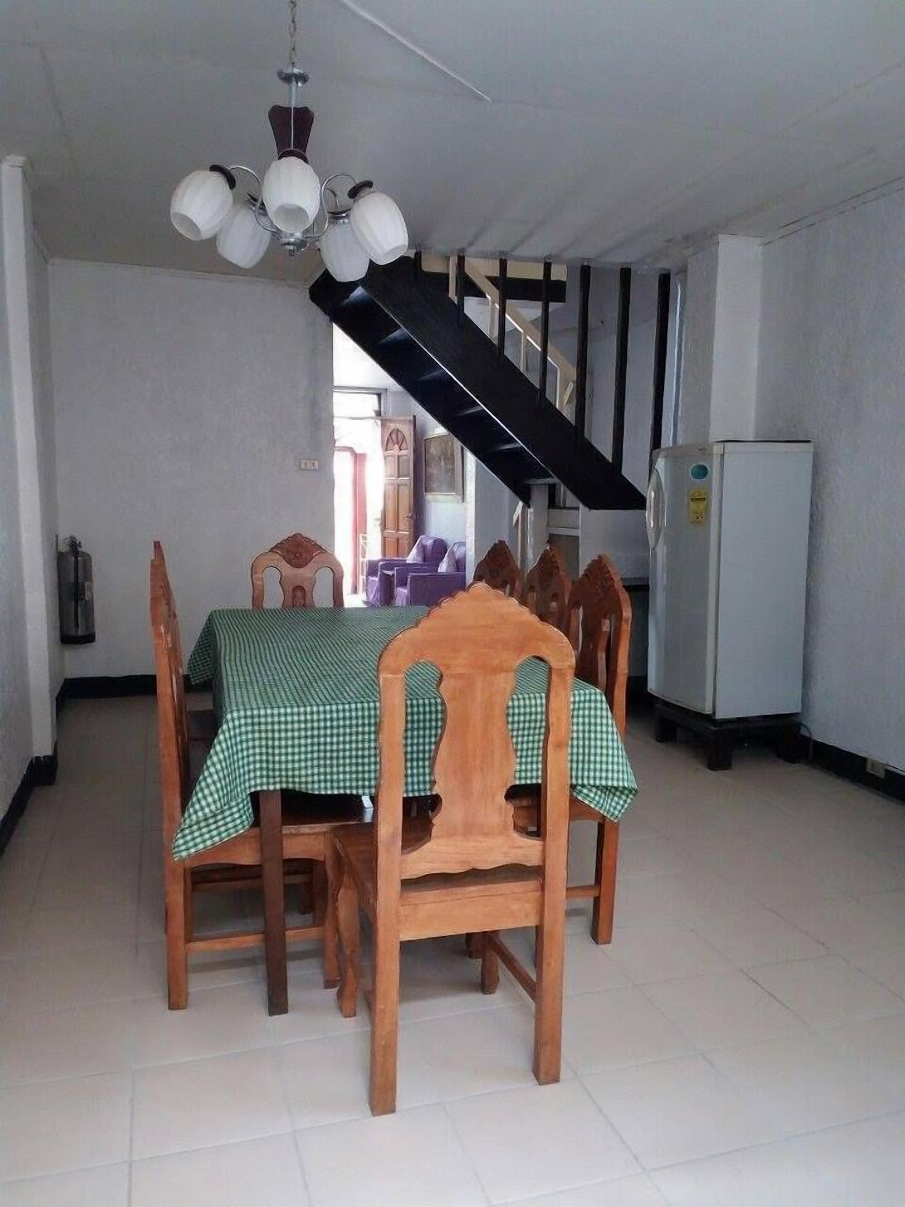 A dining area with a table set for four, wooden chairs, and a ceiling fan.