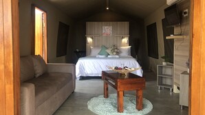 Une chambre à coucher de taille réduite, comprenant un lit, une table de chevet et un petit coin salon.