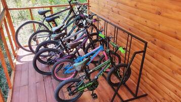 Una terraza de madera con un aparcamiento metálico para bicicletas que contiene varias bicicletas.