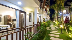 A well-lit outdoor area with a stone pathway, wooden railing, and lush greenery. - Melica Resort & Spa Phu Quoc (Phu Quoc)