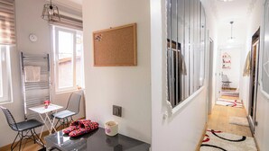 A modern kitchen with a black countertop, a white table, and two black chairs. - Gorgeous Two Bedroom Apartment in Taksim - 3AC (Istanbul)