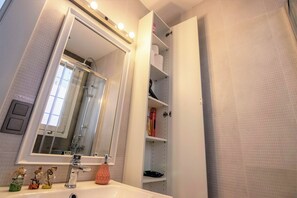 A bathroom with a large mirror, a sink, and a shower area. - Gorgeous Two Bedroom Apartment in Taksim - 3AC (Istanbul)