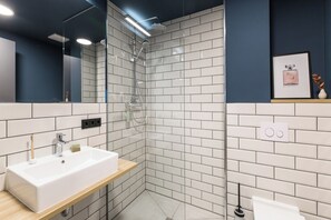 Superior Studio | Badkamer | Een douche, een haardroger, handdoeken, toiletpapier