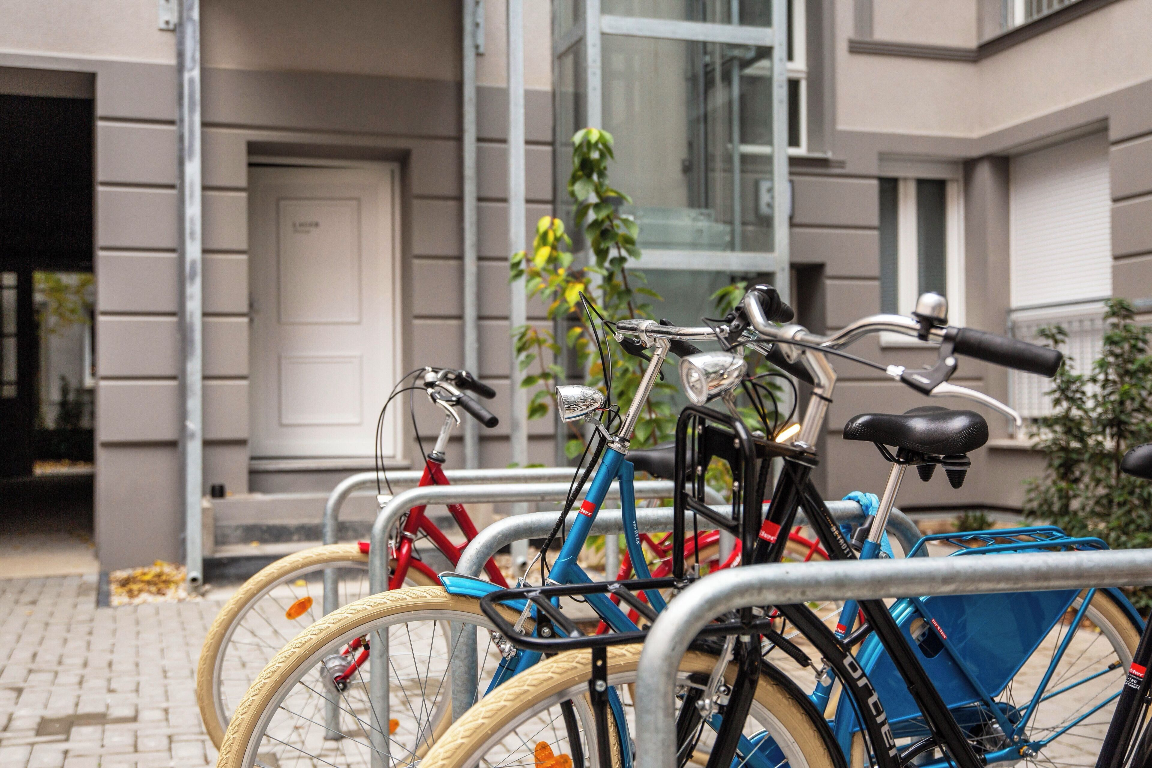 Varias bicicletas estacionadas frente a un edificio con puerta y ventanas.