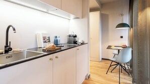 Een moderne keuken met een roestvrijstalen spoelbak, een koffieapparaat en een brood op het aanrecht.