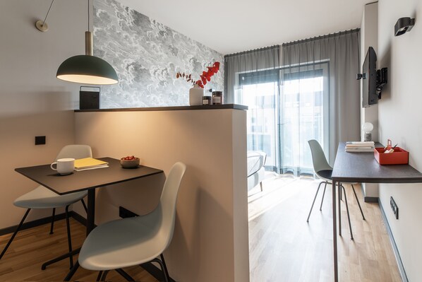 A modern dining area with a table, chairs, and a pendant light.