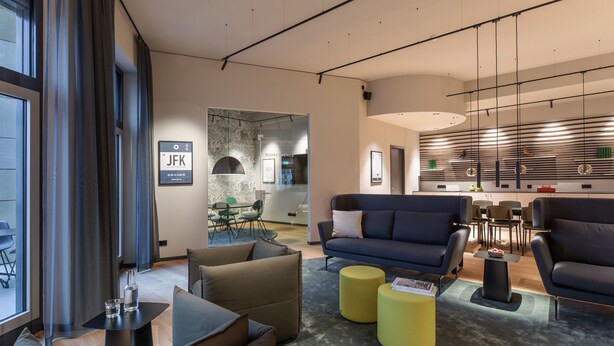 Een modern interieur met een bank, fauteuils en een eethoek.
