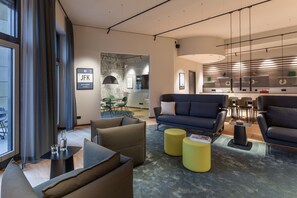 A modern interior with a sofa, armchairs, and a dining area. - ipartment Frankfurt Airport (Frankfurt)