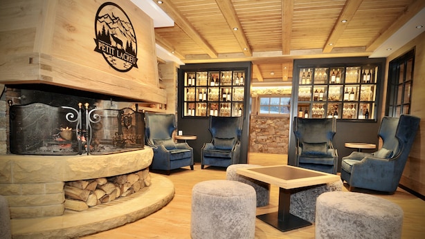 Ein gemütlicher Lounge-Bereich mit Kamin, bequemen Sitzgelegenheiten und einer Weinauslage.