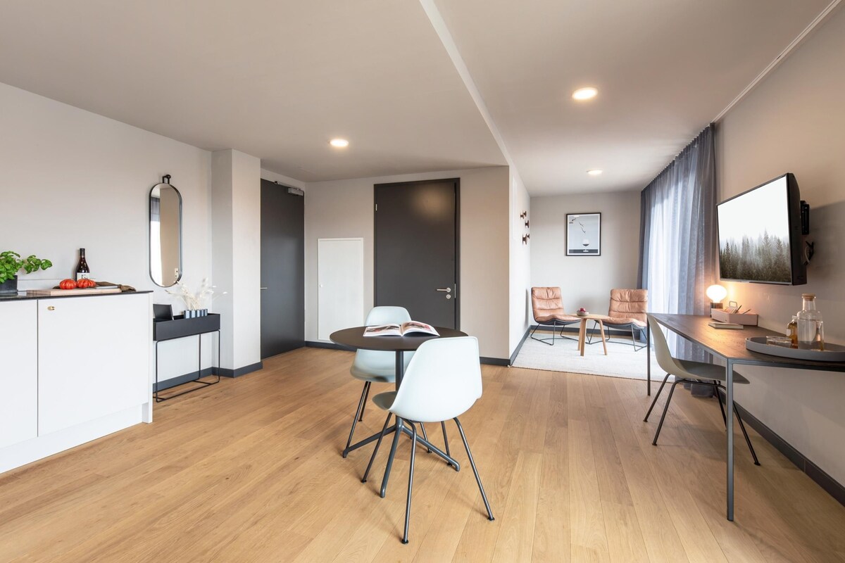 Ein modernes Hotelzimmer mit Essbereich, einer Küche und einem Wohnbereich.