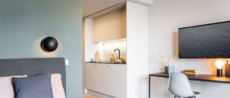 Une chambre moderne comprenant un lit, une table de chevet et un espace bureau avec une chaise.