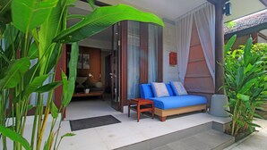 Ein Zimmer mit einer Couch, einem kleinen Tisch und einer Tür zu einem weiteren Raum.
