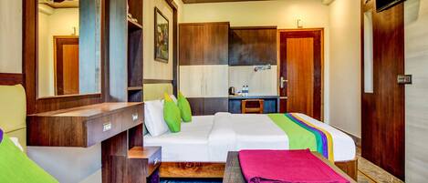 A hotel room with a bed, a desk, a chair, a wardrobe, and a television.