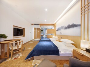 A hotel room with a bed, bedside table, lamp, TV, and a view of a mountain landscape. - Qianna Hotel Zhengzhou Jingguang Road (Zhengzhou)